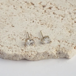 18k gold-tone minimalist stud earrings featuring a single, brilliant pear-shaped crystal in a classic three-prong setting