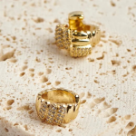 18k gold-tone huggie earrings featuring a textured ribbed design with alternating sections of brilliant pavé crystals.