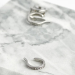 A sleek, rhodium-plated sterling silver ear cuff featuring a continuous row of shimmering micro-pavé crystals along its outer edge