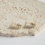 18k gold-tone open C-hoop earrings featuring a linear row of high-brilliance round crystals secured by prominent prismatic prongs