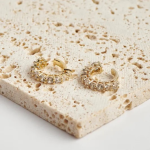 18k gold-tone ear cuffs featuring a row of prominent, round brilliant-cut crystals secured in an elevated prong "crown" setting