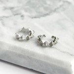 Rhodium-plated ear cuffs featuring a series of sharp pyramid studs, each meticulously accented with shimmering pavé crystals