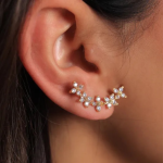 A refined gold-tone ear climber featuring a series of crystal-accented floral clusters that trace the natural contour of the ear
