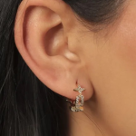 Elegant gold-tone huggie hoop earrings featuring a unique U-shaped link design adorned with delicate pavé-crystal star motifs