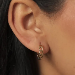 A pair of gold-tone stud earrings shaped as a delicate, open-crescent moon, adorned with a series of pave-set clear crystals