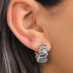 A pair of small, bold silver-tone huggie earrings featuring a unique, sculptural ribbed design with organic, wavy textures