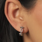 A pair of modern silver-colored huggie earrings featuring a unique vertical design of three interlocking crystal-encrusted circles